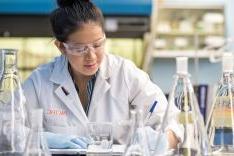 Student wearing lab coat in research lab