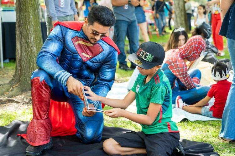 在斯托克顿公园一年一度的家庭日上，一名参加社区参与项目的学生给孩子们朗读. 