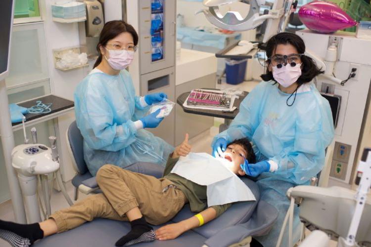 孩子坐在牙医的椅子上