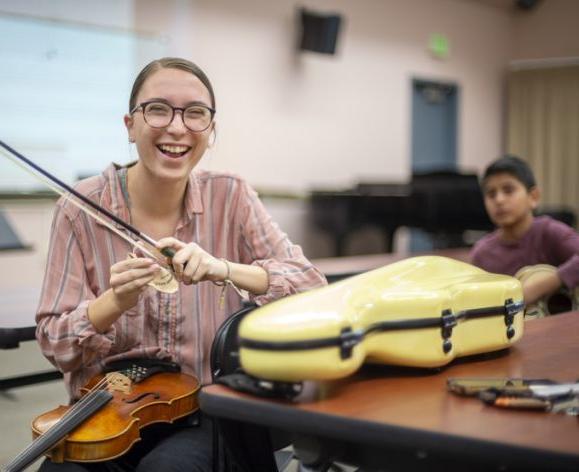 一个快乐的音乐老师拿着小提琴